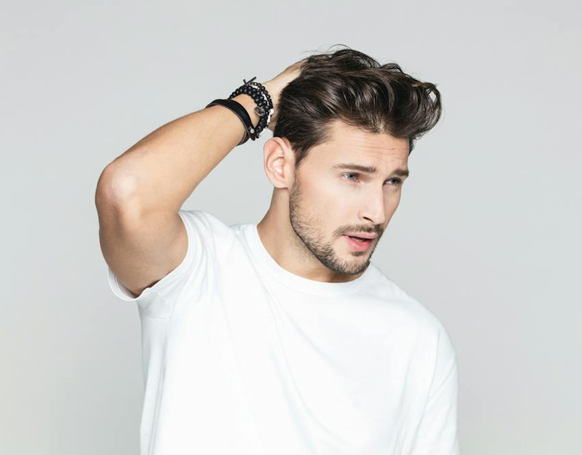 A man touching his hair