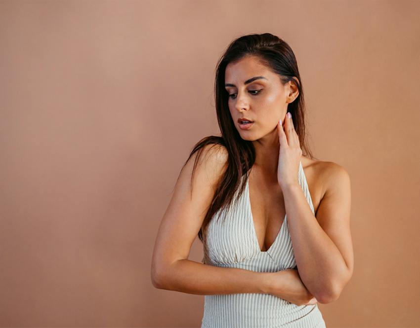 woman touching her neck