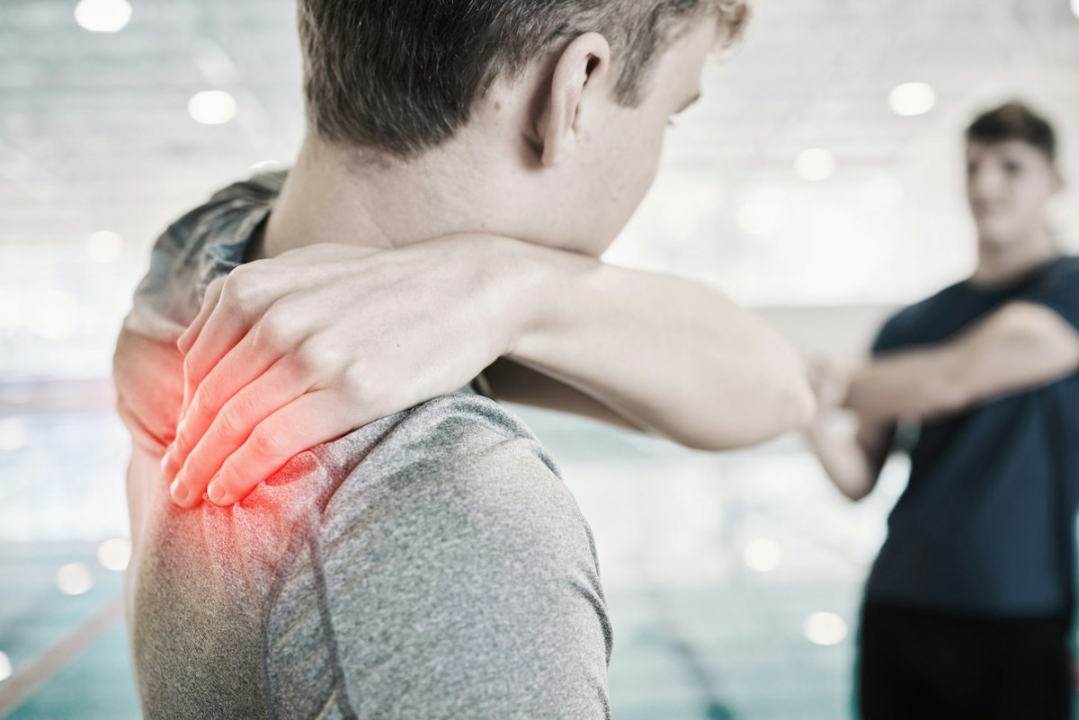 Man holding his neck and shoulder due to muscle spasm pain, representing neurological muscle spasms and cervical dystonia treated with medical Botox therapy