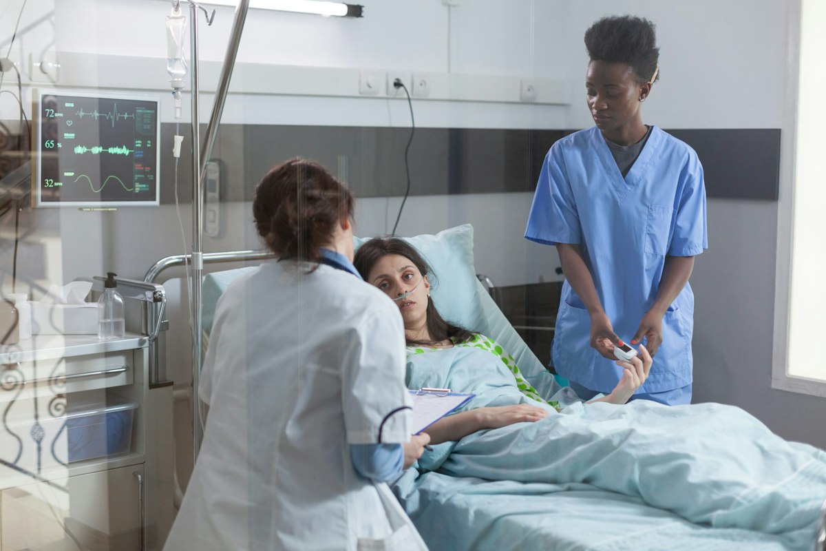 Patient receiving hospital level emergency care with medical team monitoring vital signs and oxygen support