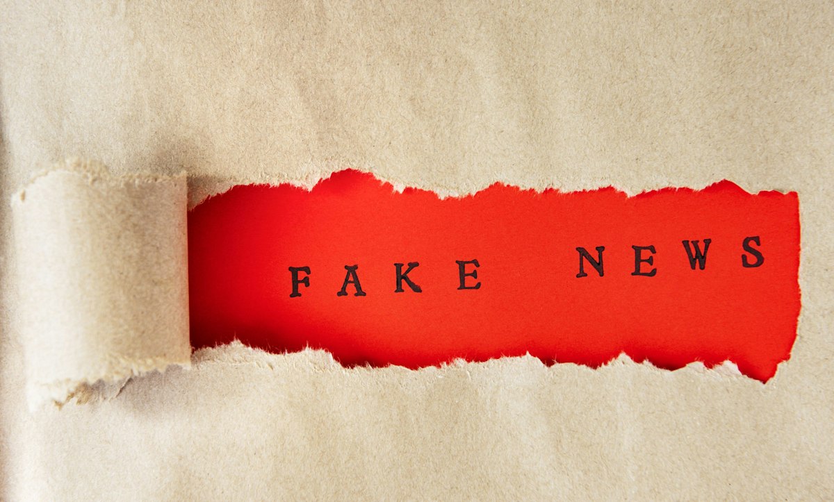 A torn fake newspaper with the words fake news visible, symbolizing common misinformation surrounding Botox and the need for medically accurate guidance.