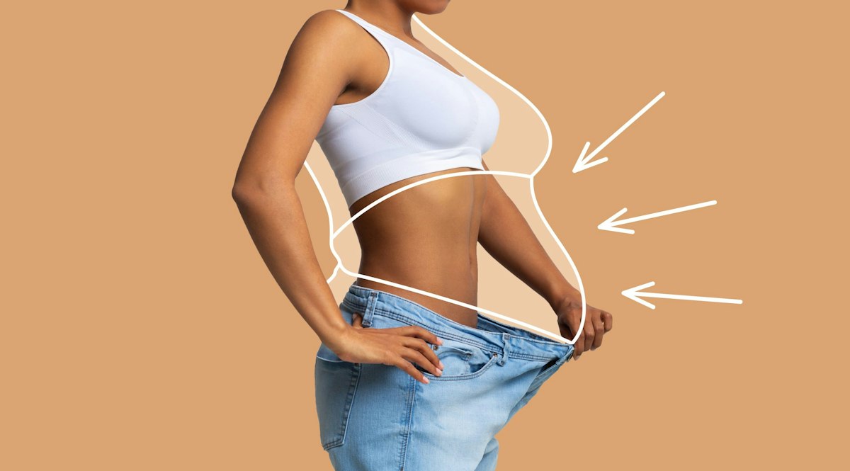 A young African American woman showing significant weight loss by wearing oversized jeans after completing a physician guided weight loss program at Geneva.