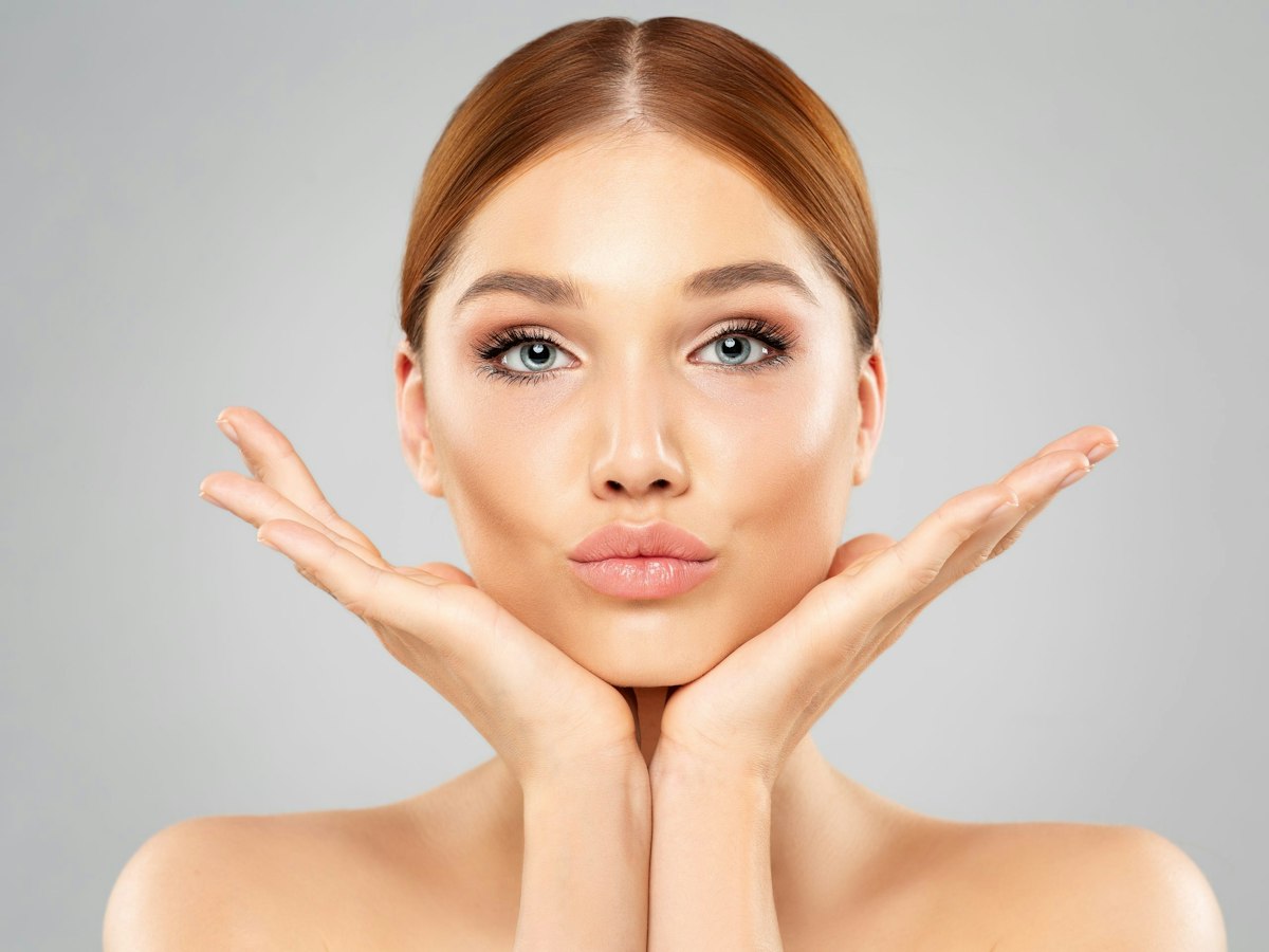 A beautiful woman with sculpted cheekbones and naturally full lips after a physician guided filler treatment at Geneva.