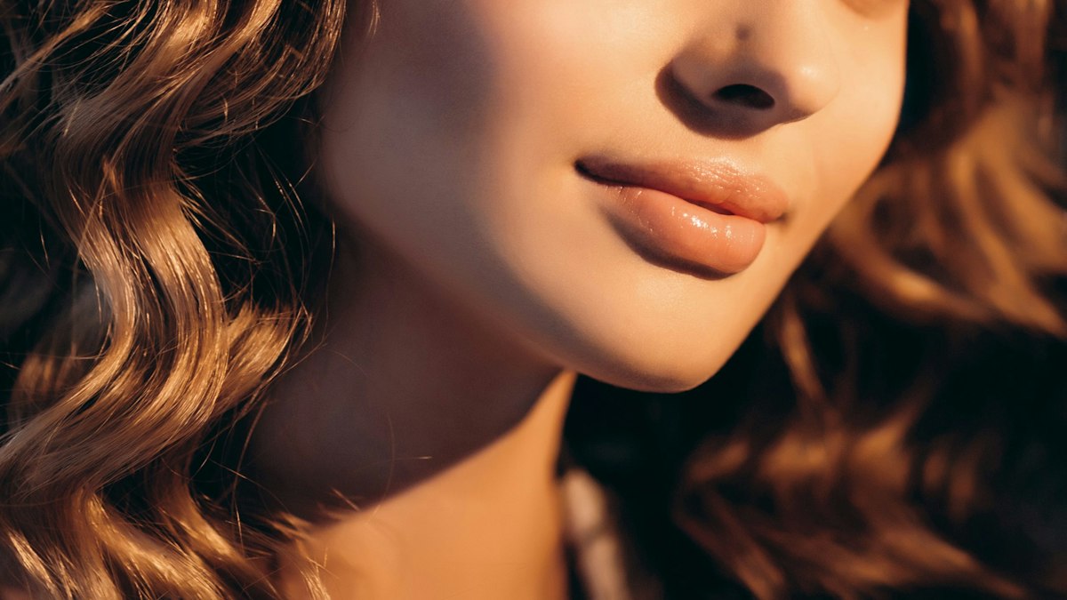 A detailed close up of a woman at Geneva showing smooth skin and subtly refreshed lips after filler.