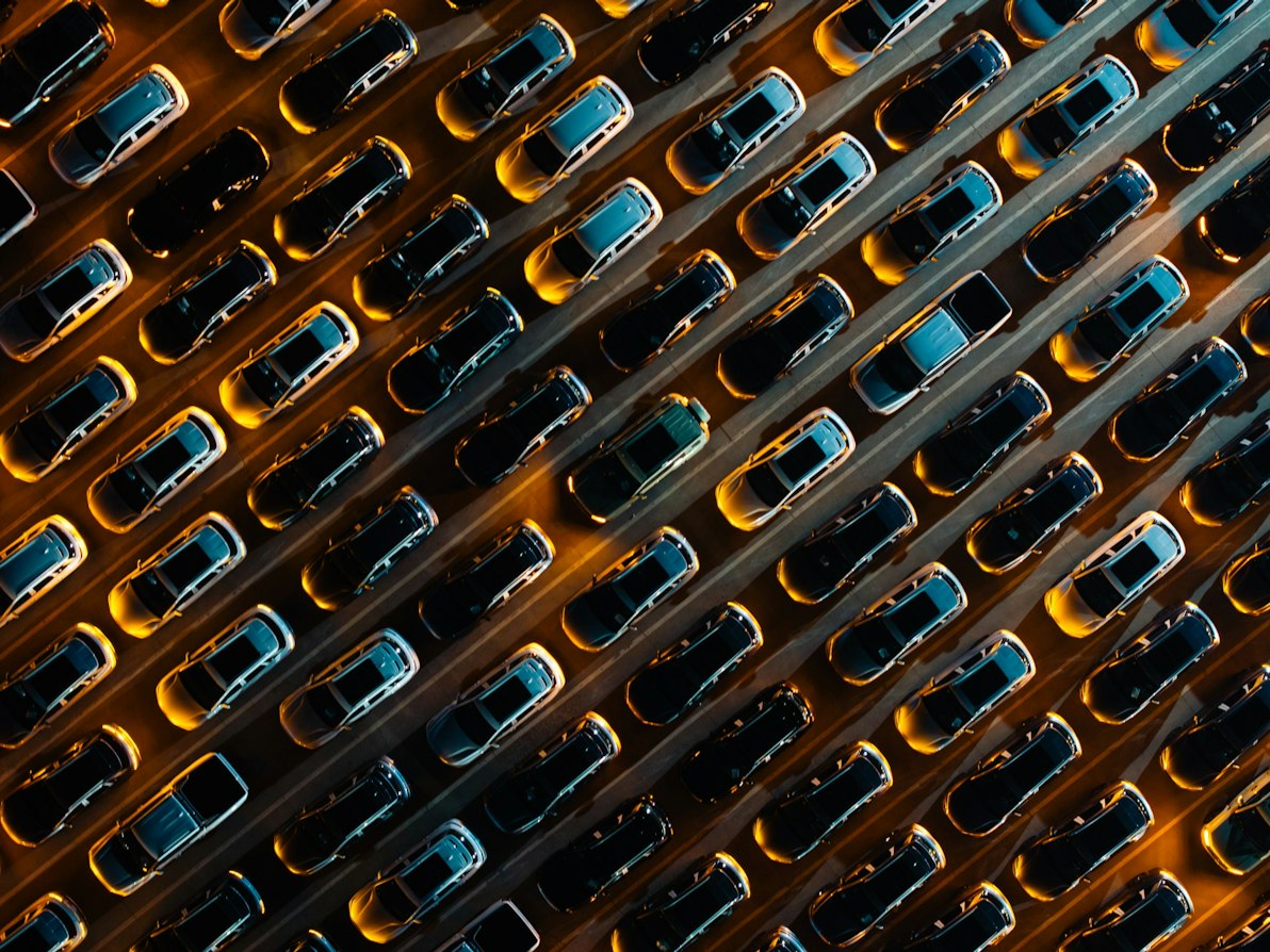 Veicoli parcheggiati in file diagonali, visti dall'alto in un parcheggio multipiano