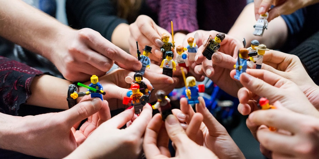 group of people holing lego models in their hands