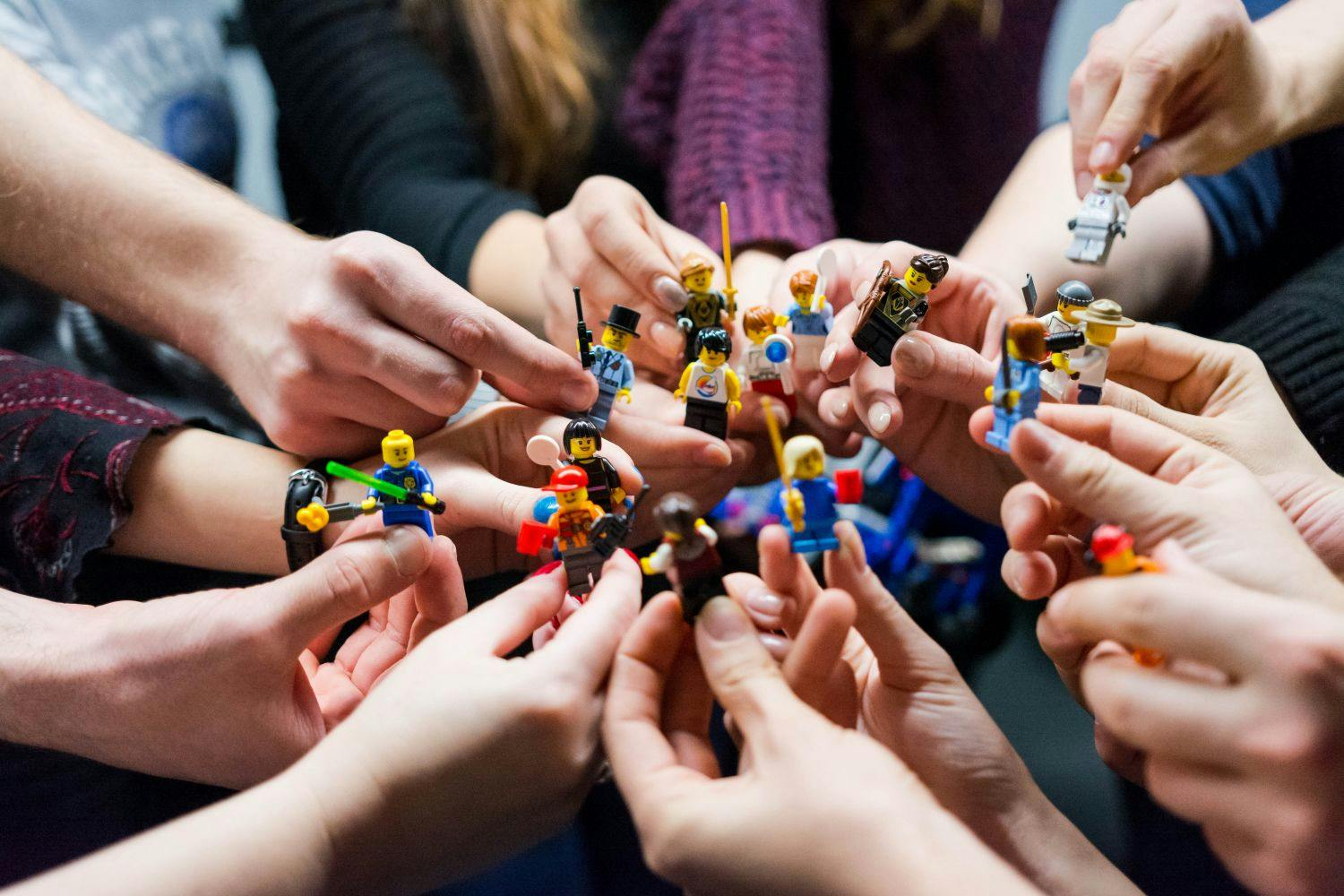 group of people holing lego models in their hands