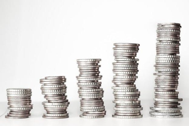 A stack of coins arranged in a pyramid shape, with varying sizes and angles. A stack of coins arranged in a pyramid shape, with varying sizes and angles.