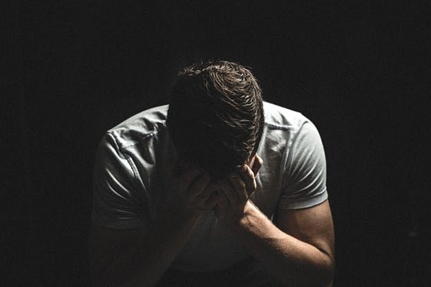 Man with his head in his hands.