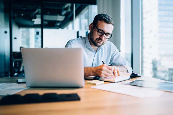 Man working next to his laptop