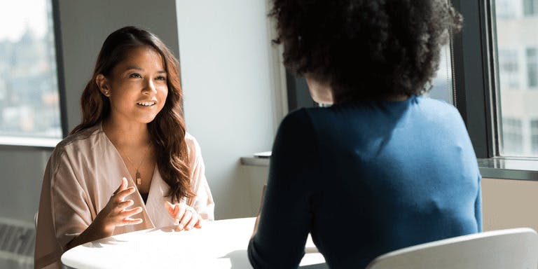 Two people having a HR strategy meeting across a table