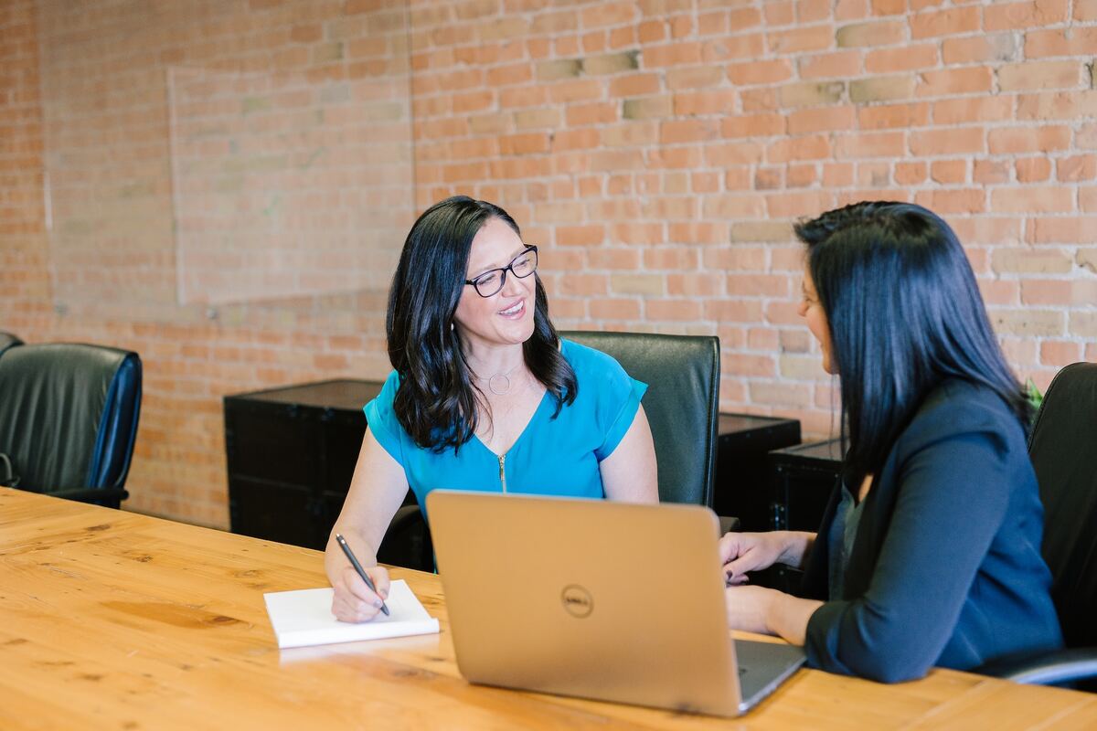 Two people having an exit interview in an office with a laptop