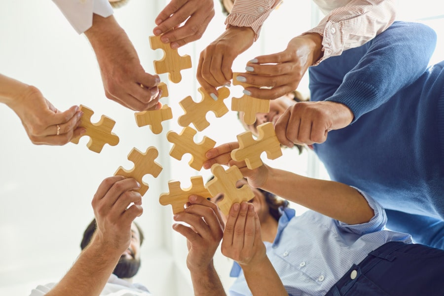 Group of people holding puzzle pieces