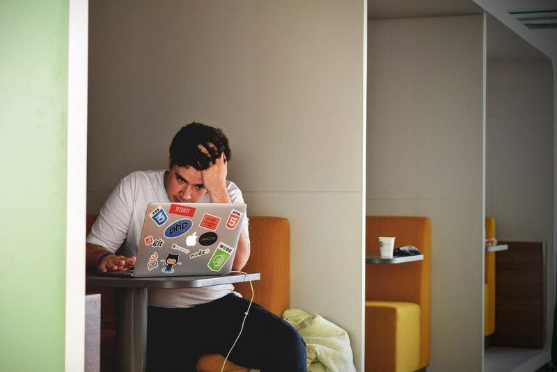 Man sat in cubicle looking anxious