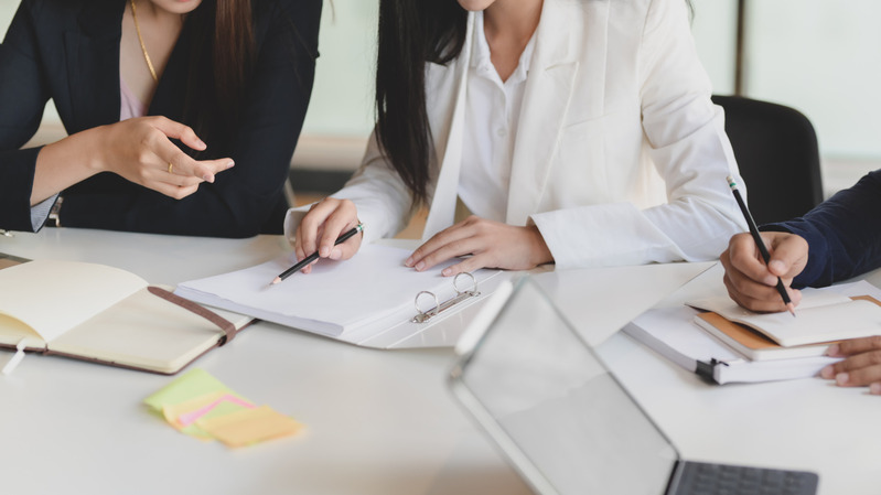 People meeting over disciplinary notes on a desk