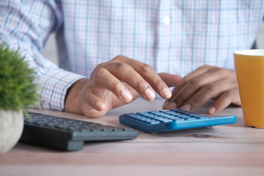 Person using a calculator to work out how much to pay in annual leave loading
