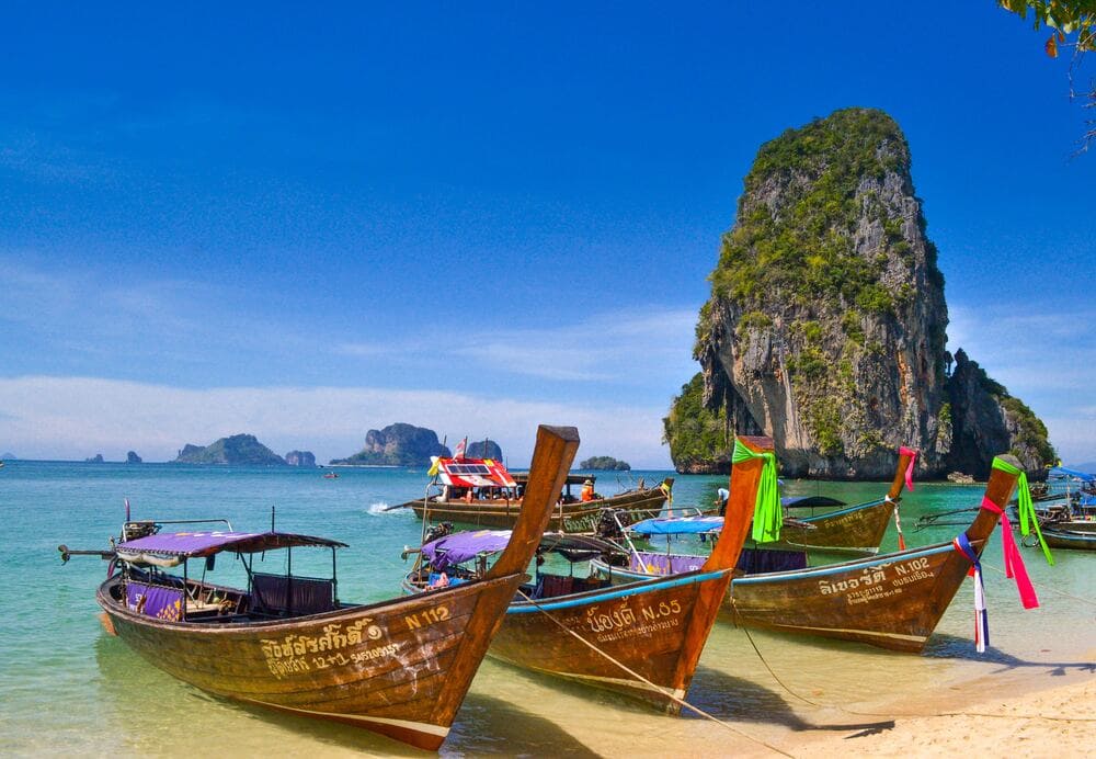 A holiday picture of some boats docked on a beach in Thailand