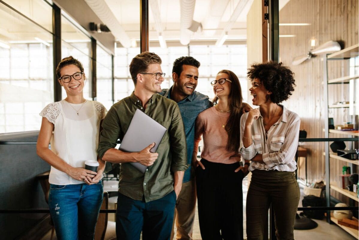 5 people smiling due to working in a successful team