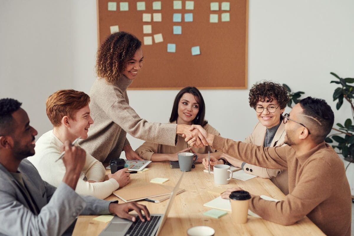 6 people having a team meeting over a table and working well together