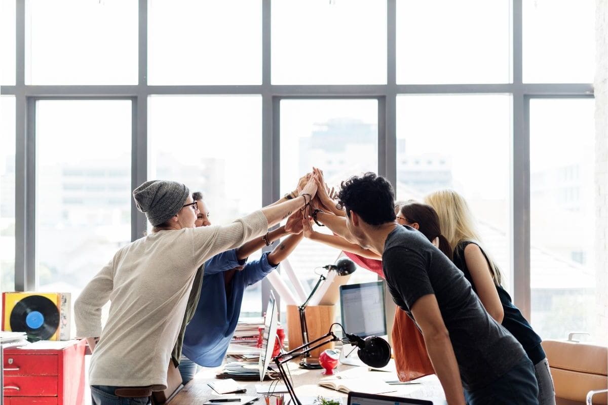 Group of team members high fiving each other