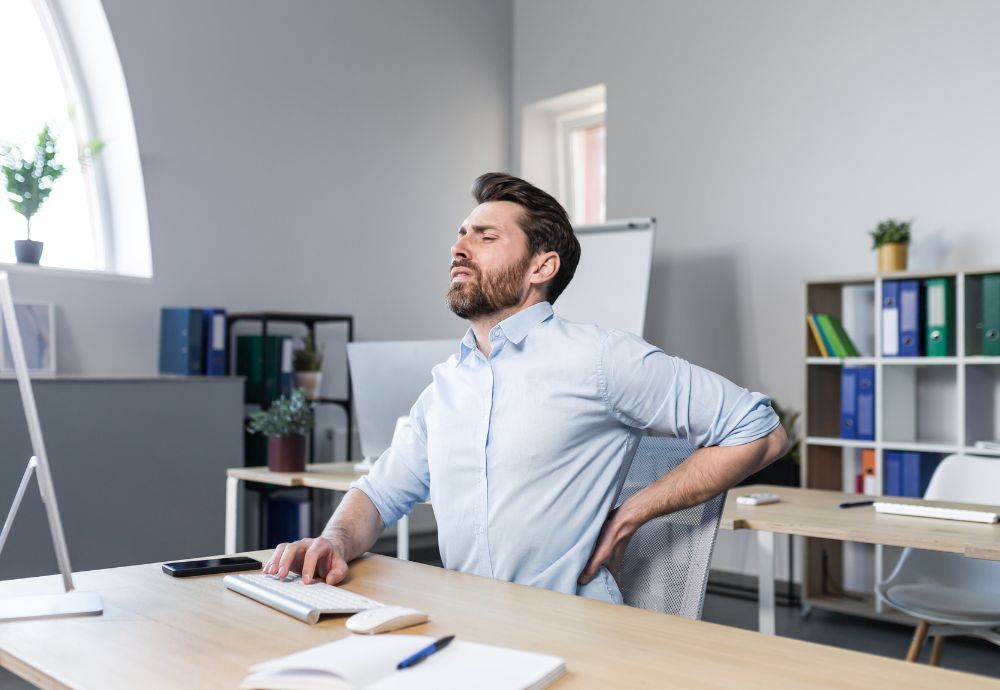 Person sitting in a office with fatigue and back pain