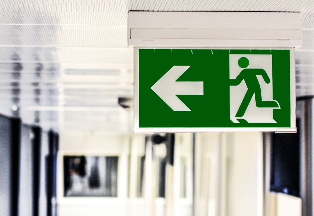 Exit sign pointing someone who has quit their job where to leave
