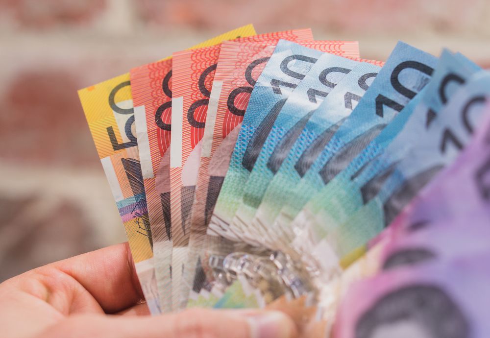 A person holding some Canadian dollars after receiving the average wage