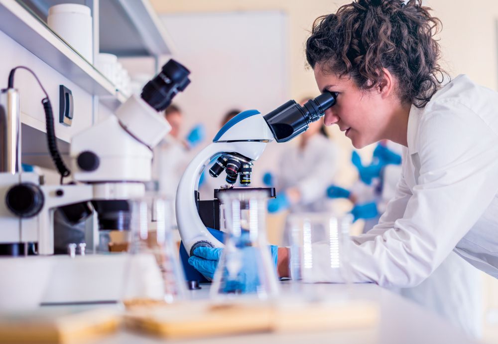 A scientist looking through a microscope on a high average wage in canada