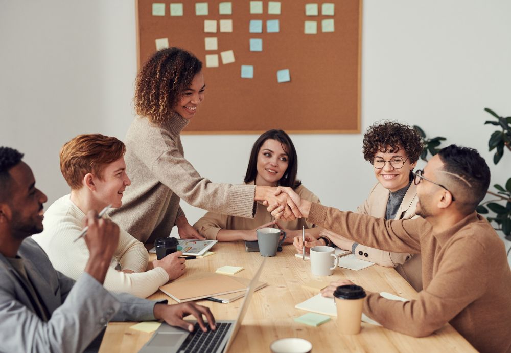 two people shaking hands after an new employee is being introduced