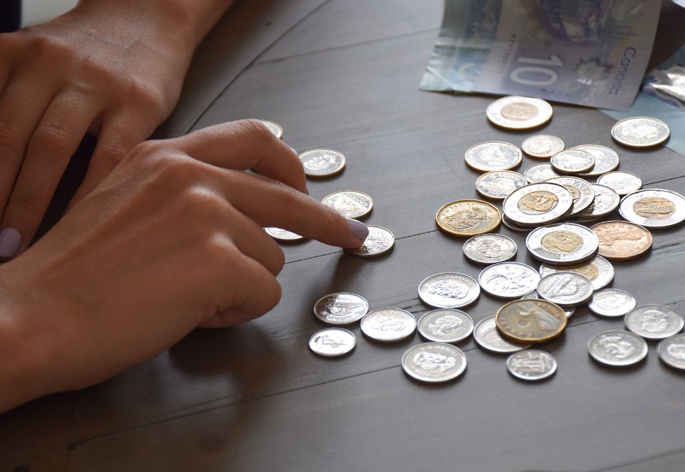 Someone counting coins after having a payroll deduction