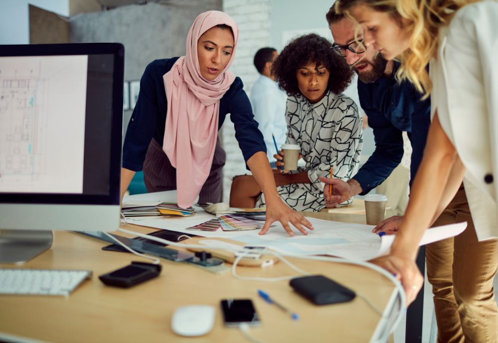 A group of people having a meeting over a table