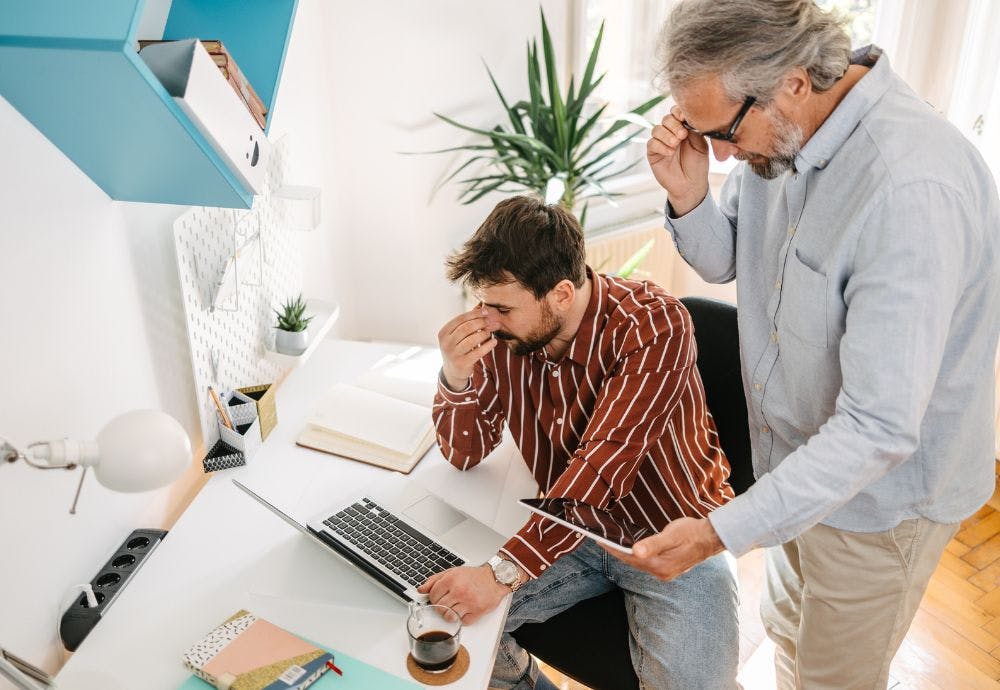Micromanagement in the workplace A manager watching over the work of an employee in an office environment