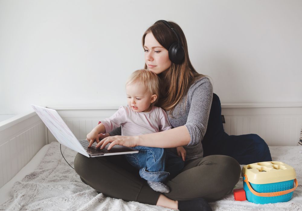 A mum working from home with her child due to work offering flexible working arrangements