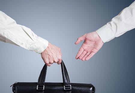 Handover 2 people handing over a bag of work a process documents