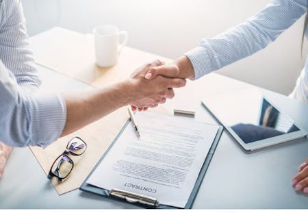 New Job contract Two people shaking hands over a new job contract