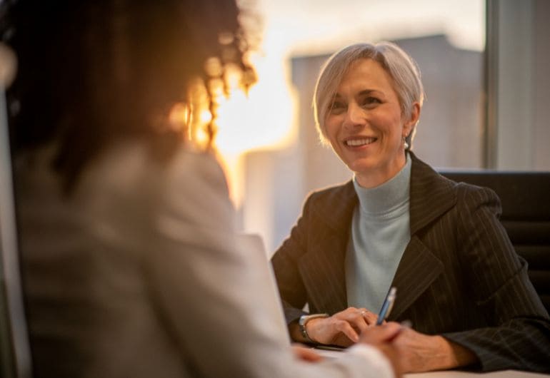 2 people having a meeting where one person has completed their probation period