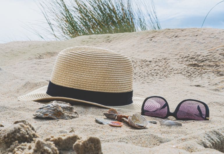 Sunglasses and hat on the beach