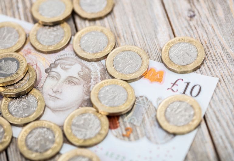 A collection of British coins and ten pound note