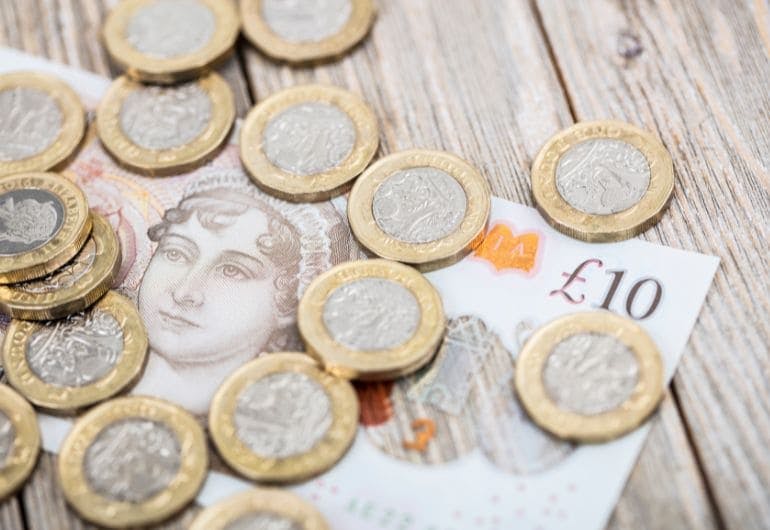 A collection of British coins and ten pound note