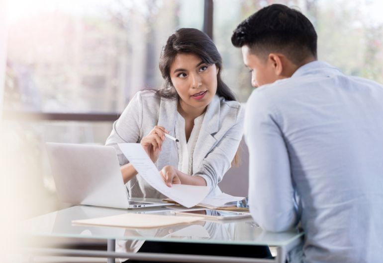 A person handing  a document to someone extending probation period