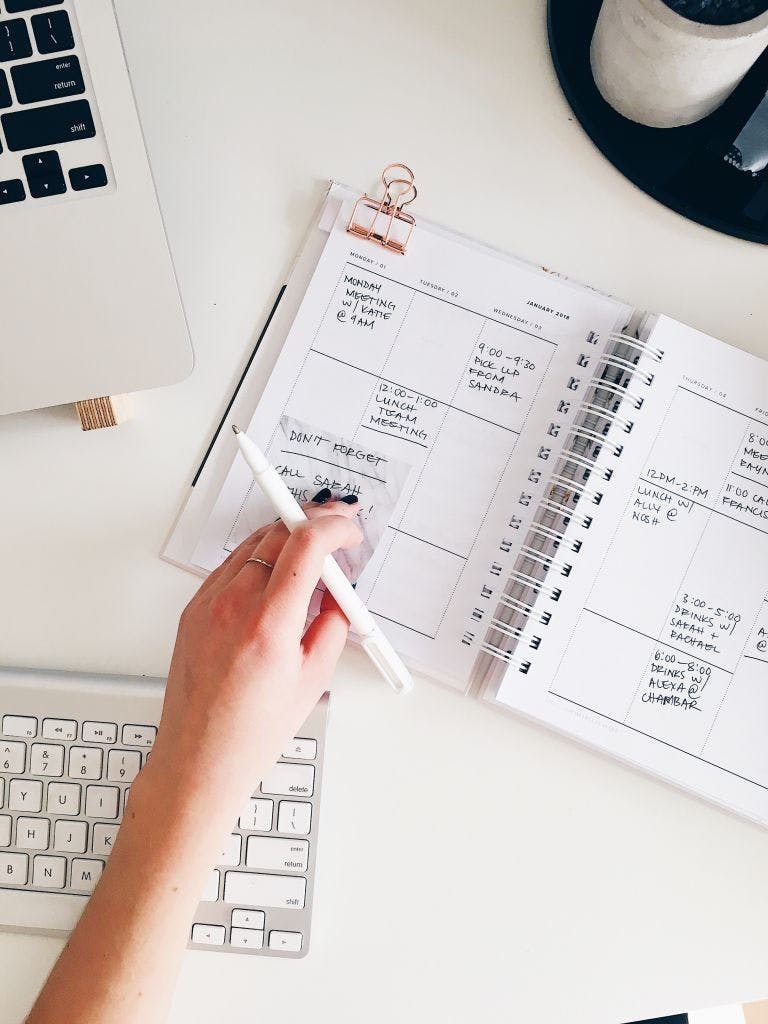 keyboard, diary and hand with pen