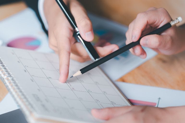 Planning employee holiday entitlement Employer and employee planning out annual leave on a calendar