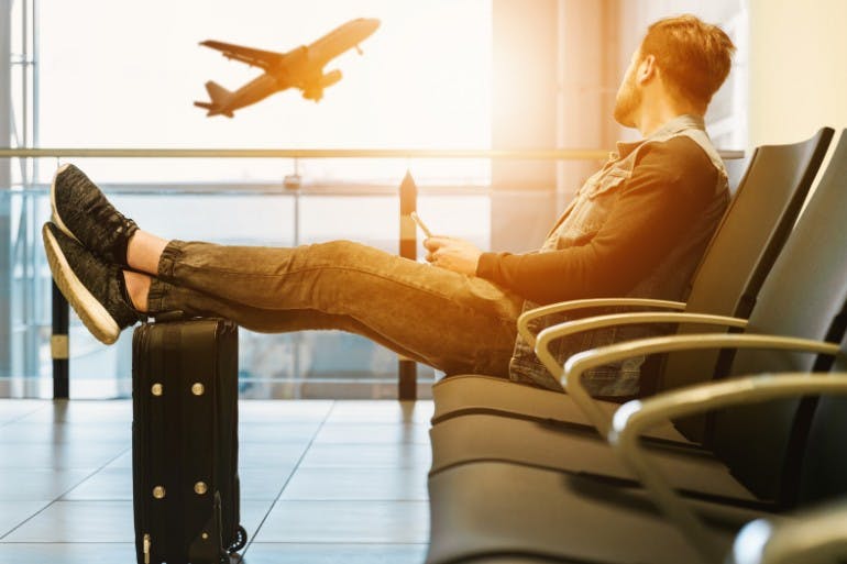 Accepting holiday request when flights are booked Male employee waiting for a flight at the airport