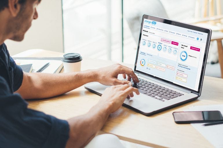 Outsourced HR Software on Laptop business owner using brighthr software on laptop