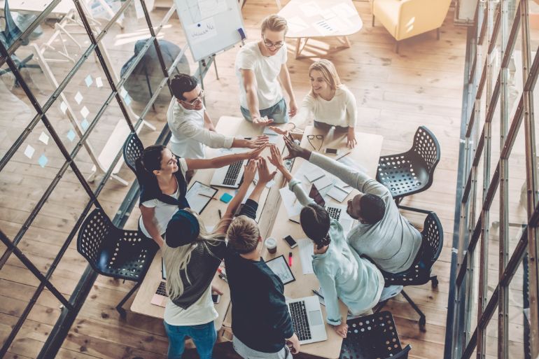 happy employees gathered round their workspace