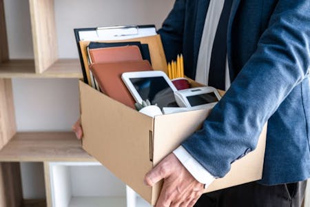 end of contract employee holding box of work documents after an end of contract