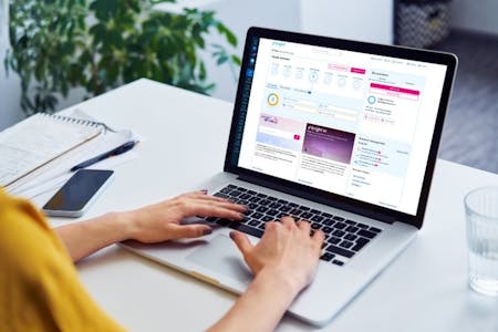 What is HRIS? A woman focused on her laptop, typing away while using brighthr