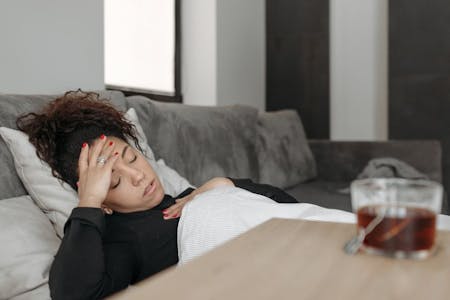 Types of leave from work Female employee sick on couch taking sick leave