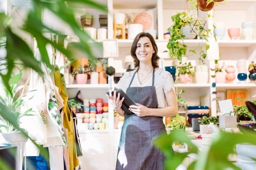 Female business owner using an HR app on a table in her store.