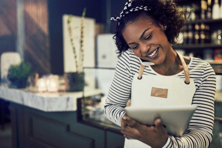 Resturant owner us on a tablet, creating a clocking in an out policy.